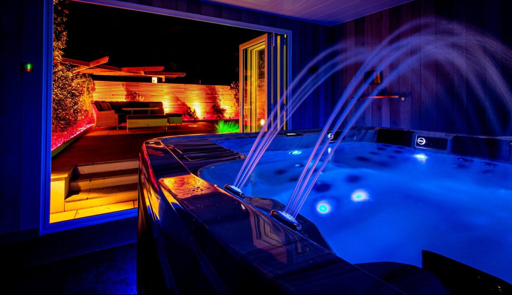 Prižgane fontane in luči masažnega bazena v temi.